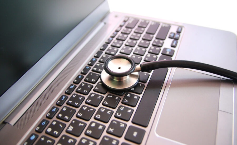 Stethoscope on a modern laptop keyboard, symbolizing telemedicine or online healthcare services.