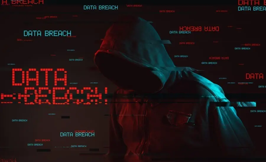 Hooded figure in red digital noise with the words 'Data Breach' repeating across the image, symbolizing a hacker attack and the threat of compromised data security.