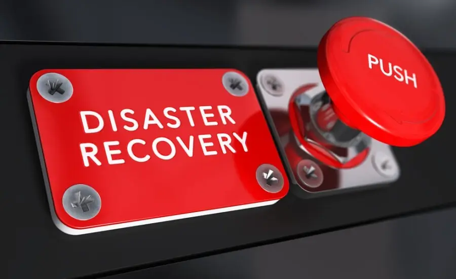 Red disaster recovery sign mounted on a wall with a large push button, indicating emergency procedures and business continuity planning.