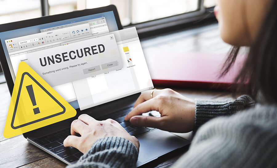 Woman using a laptop displaying a prominent 'Unsecured' warning sign and alert message, illustrating concerns about digital security and unprotected internet connections.