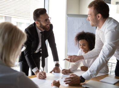 Enthusiastic business team engaged in a lively discussion around a conference table, signifying collaborative teamwork, corporate strategy meetings, or brainstorming sessions.