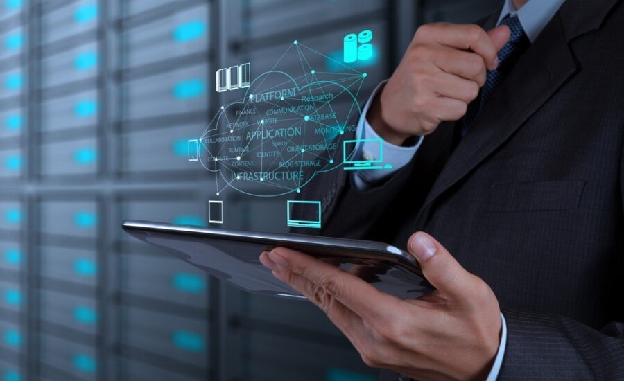 Business professional using a tablet with futuristic holographic interface graphics, symbolizing advanced technology in data management, analytics, or cloud computing.